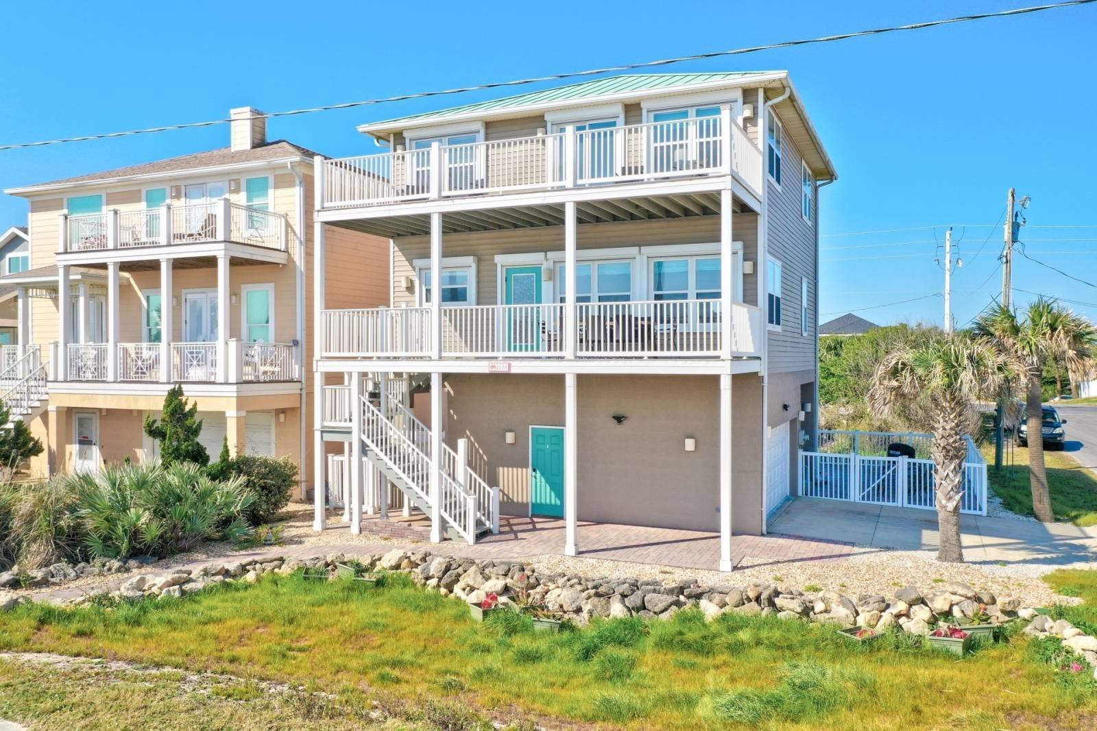 Front of the house, three-story stilted, with attached garage