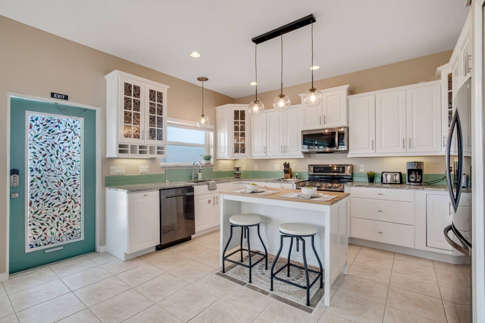Kitchen with island, bar stools, and pendant lighting