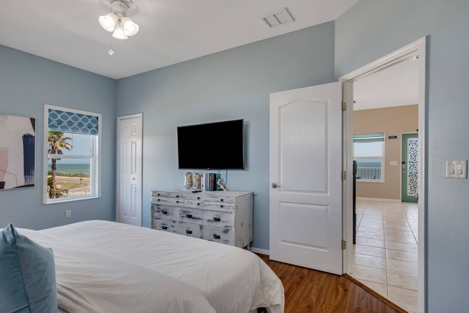 Bedroom with mounted TV and dresser
