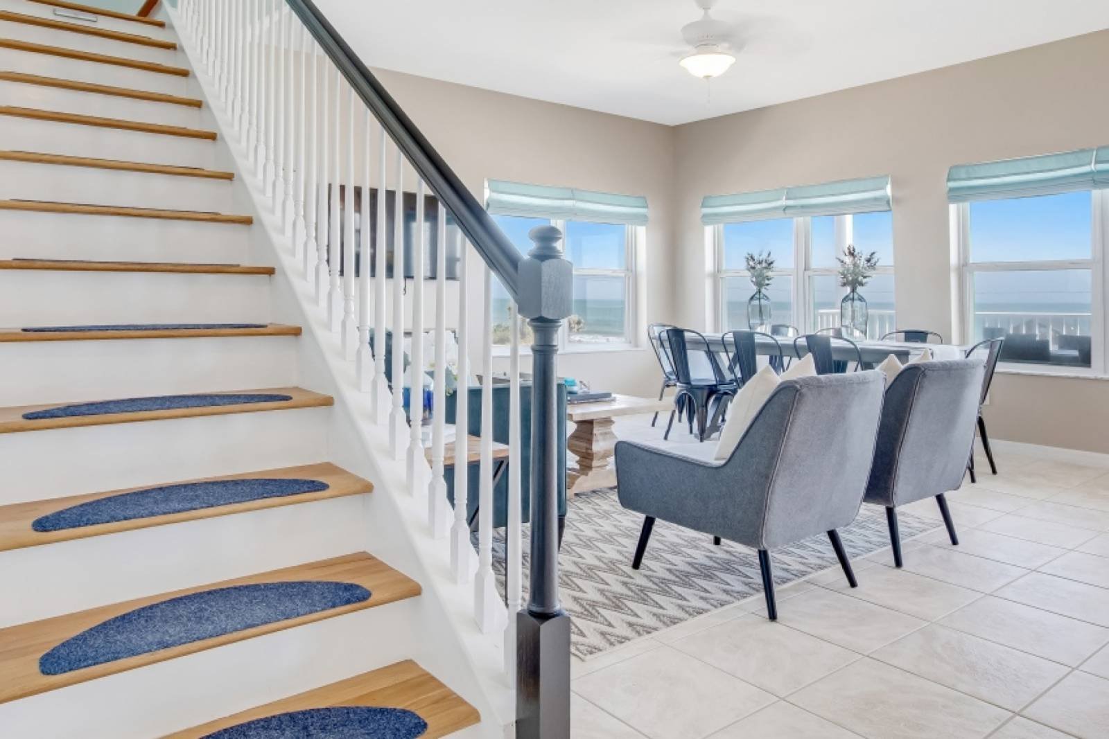 Stairs descending to the open main level with ocean light