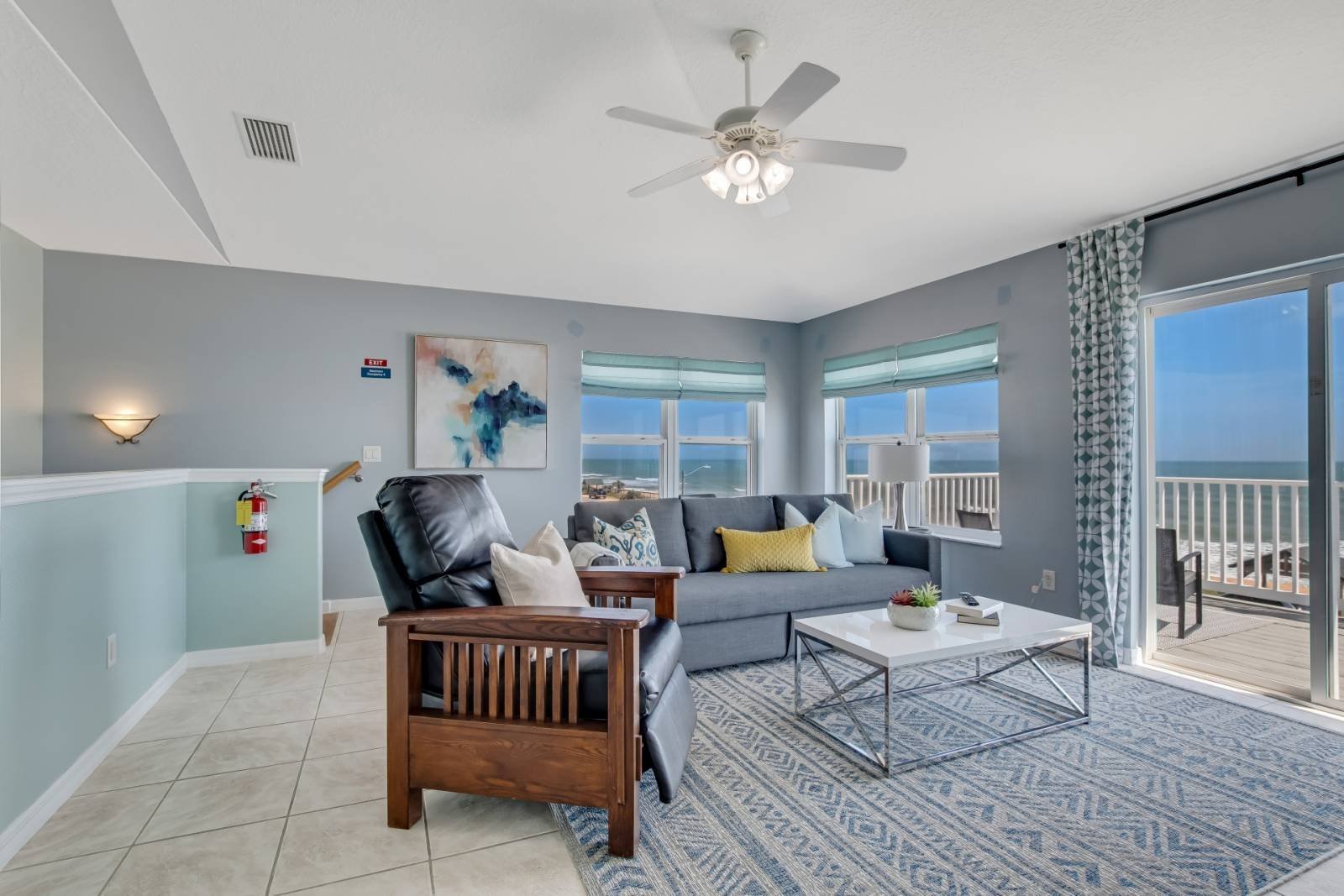 Upper living area with leather chairs and balcony slider