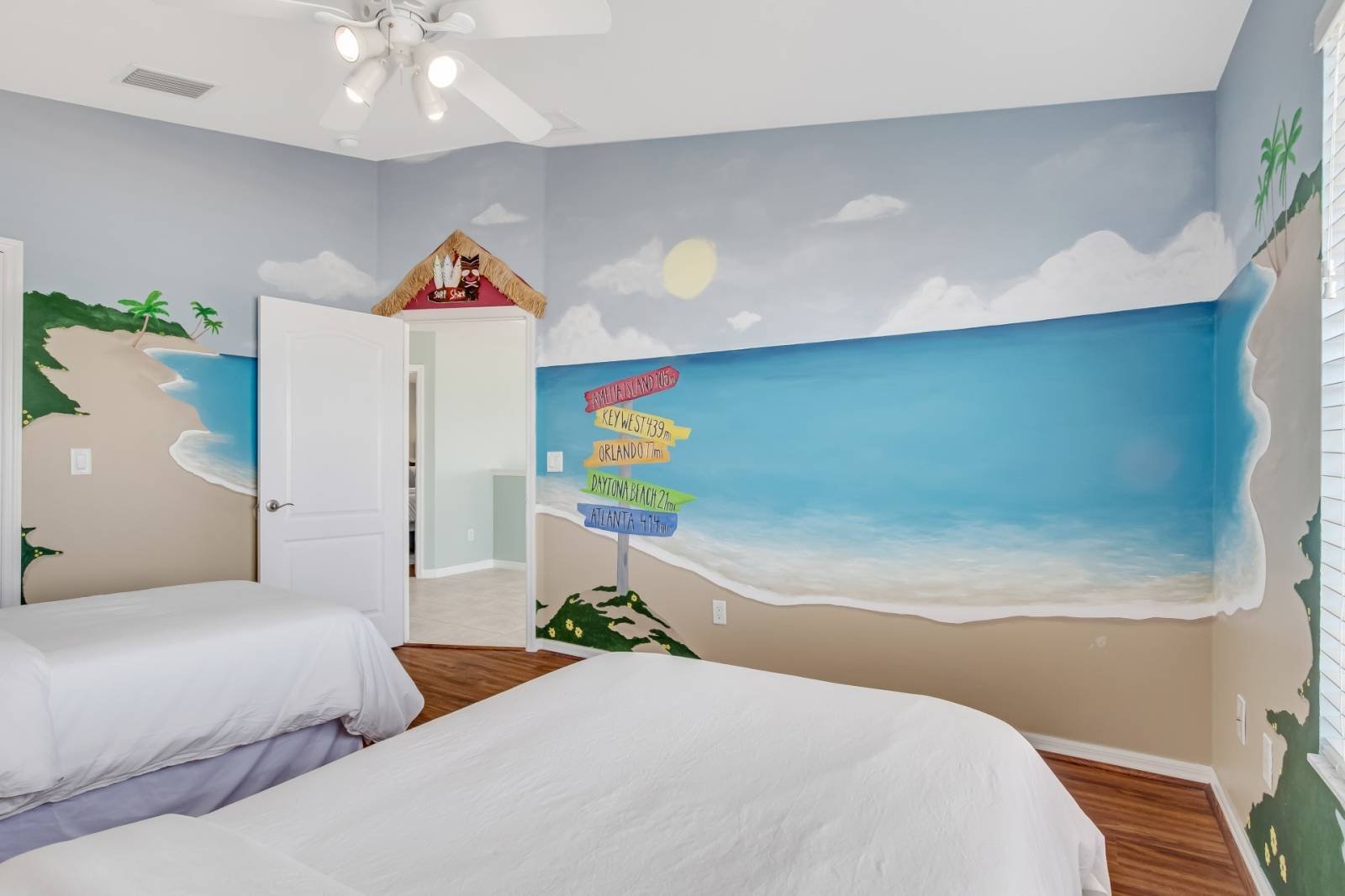 Guest room with two twin beds and beach mural